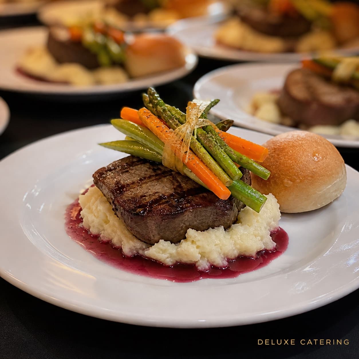 Grilled beef medallion over mashed potatoes with red wine sauce and a bundle of asparagus and carrots